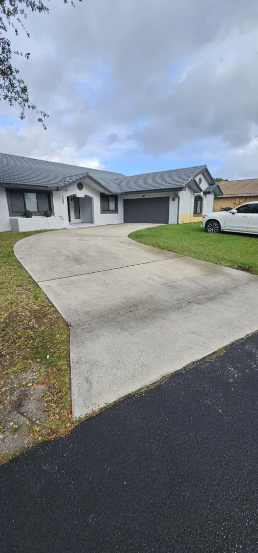 Miramar concrete driveway with algae and rust stains before pressure washing